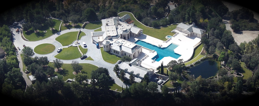 Helicopter view of a house with pool