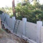 Concrete boundary wall with trees in background